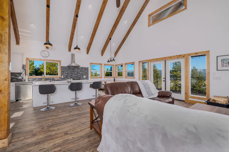Living and dining under exposed beams, windows onto the Flathead Valley, in a Built Right home above Kalispell