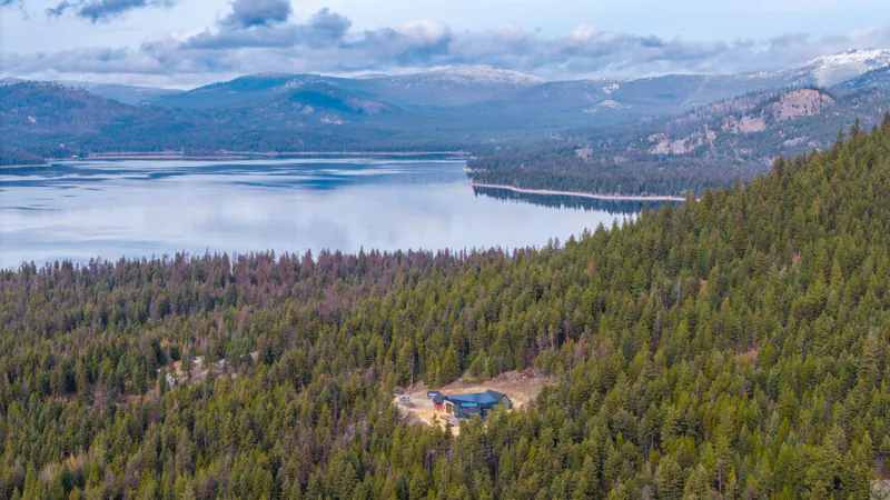 The lake and the mountains beyond it, seen from the Mountain Modern Living home site in the pines below